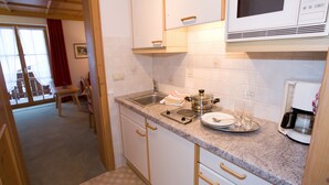 A kitchen with a microwave, stove, sink, and coffee maker. - apartment with 2 rooms (Reit im Winkl)