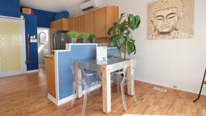 Una cocina moderna con armarios de madera, un refrigerador y plantas en macetas.