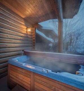 Interior de una cabaña de madera con un jacuzzi.