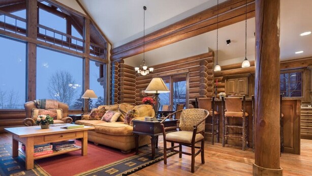 A spacious log cabin interior with a large living area, a dining area, and a kitchen. - Teton Springs Cabin with Private Hot Tub and Air Conditioning (Victor)