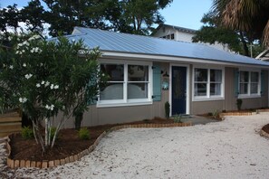 A single-story building with a metal roof, large windows, and a front door.