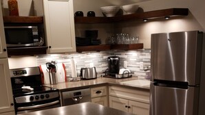 Una cocina moderna con una isla central, electrodomésticos de acero inoxidable y suelo de madera.