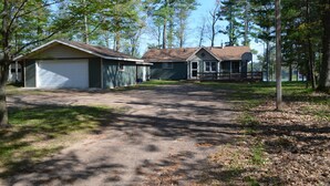 A two-story house with a garage and a covered porch. - Little Muskie Retreat on Little Muskie Lake, Canoe included!   Snowmobile! (Woodruff)