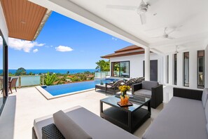 A modern outdoor living area with a pool, seating, and a view of the ocean. - Sunny Banks Villa (Koh Samui)