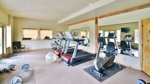A gym with treadmills, a stationary bike, and free weights.