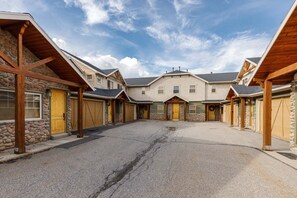 A residential building with a central entrance, multiple garages, and a stone facade.