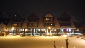 A snow-covered building with multiple windows and a covered entrance area. - Inviting Ski In/Ski Out Condo. Covered Parking. Renovated! Heated Pool/Hot Tubs! (Park City)
