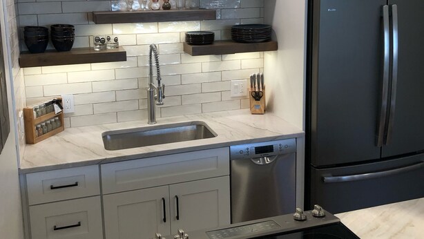 A modern kitchen with white subway tiles, stainless steel appliances, and wooden shelves. - Inviting Ski In/Ski Out Condo. Covered Parking. Renovated! Heated Pool/Hot Tubs! (Park City)