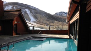 An outdoor swimming pool with a view of a snowy mountain. - Inviting Ski In/Ski Out Condo. Covered Parking. Renovated! Heated Pool/Hot Tubs! (Park City)