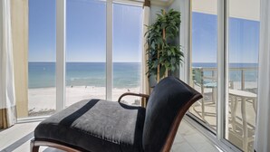 A balcony with a view of the beach, a chair, and a potted plant. - Luxury Corner Unit For The Discriminating Traveler with Double  Beach Service (Navarre)