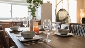 A dining table set with bowls, wine glasses, and a candle. - BB Wakugawa Terrace (Nakijin)