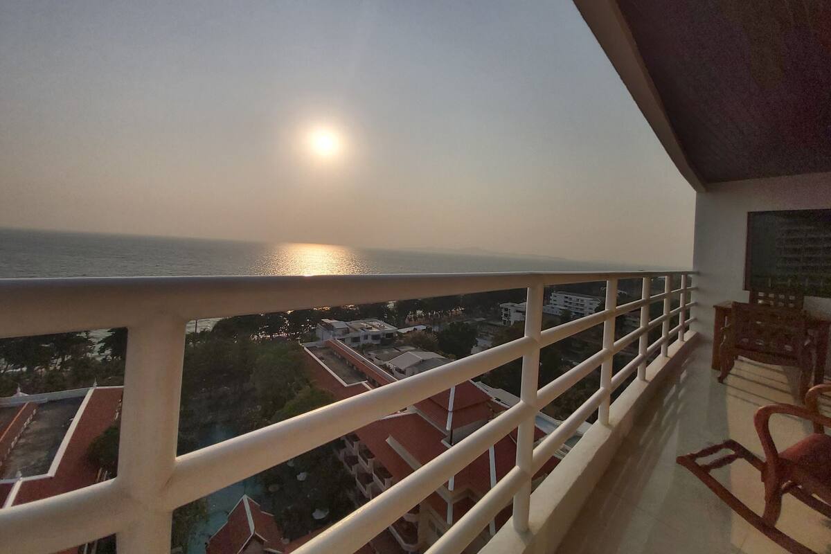 Un balcon avec vue sur la mer et les bâtiments.