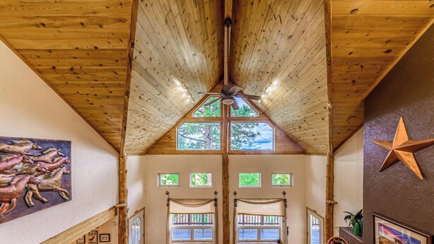 A spacious room with a high wooden ceiling, large windows, and a star decoration on the wall. - Wild Horse Lodge | Galloping Good Times Retreat w/ Game room Fun & Spacious Living (Alto)