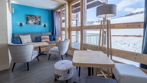Una habitación acogedora con un banco de madera, una mesa y un sofá con cojines.