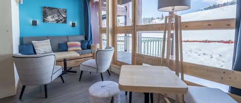 A cozy room with a wooden bench, a table, and a sofa with cushions.