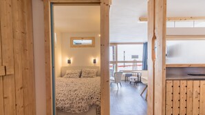 Un interior de madera con una cama, un escritorio y una ventana.