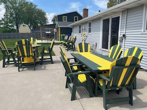 An outdoor patio with Adirondack chairs and a picnic table. - Game Day HQ w/ Fan Cave, Fire Pit + Stadium Views (Green Bay)