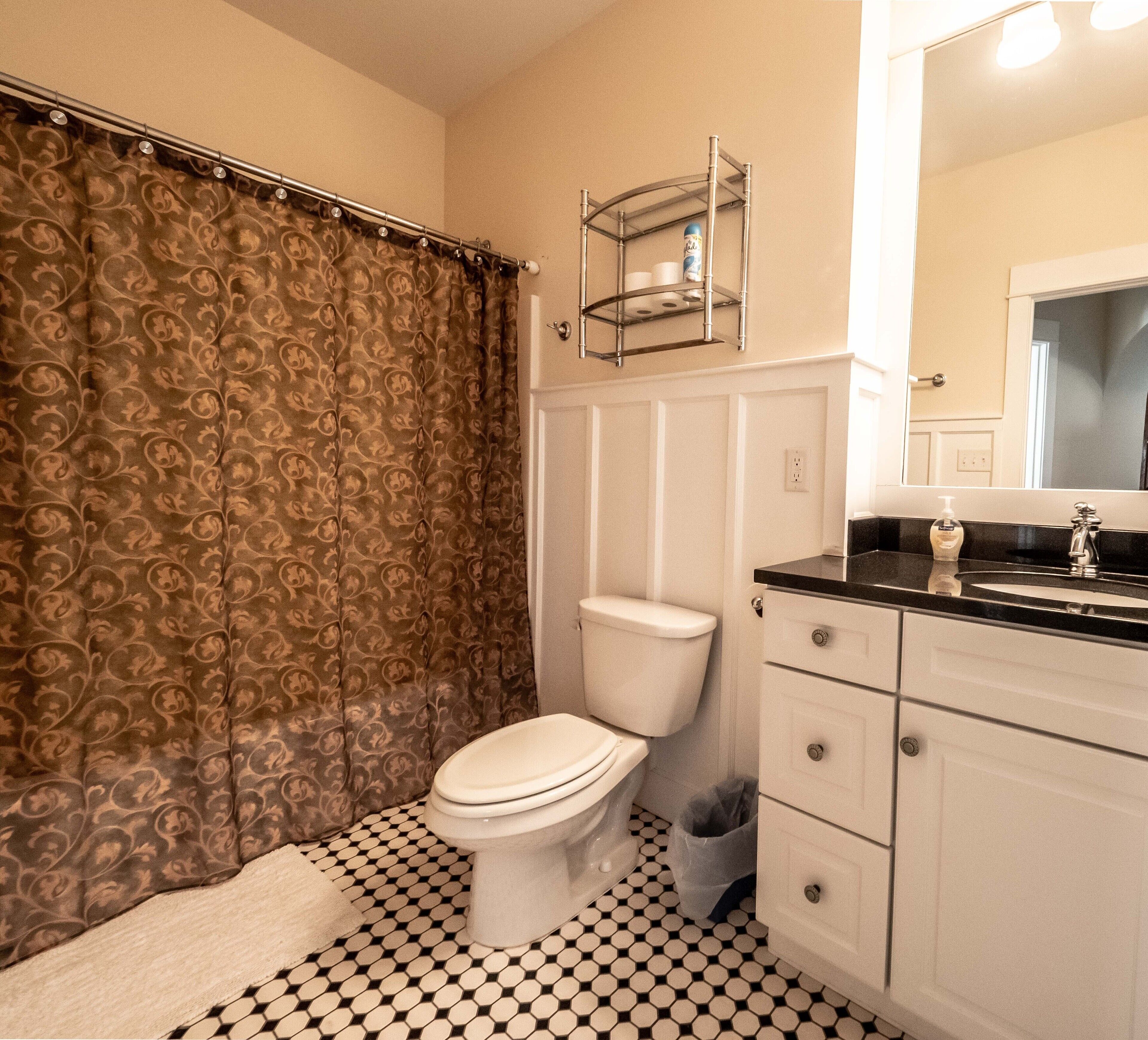 A bathroom with a toilet, a sink, and a mirror.