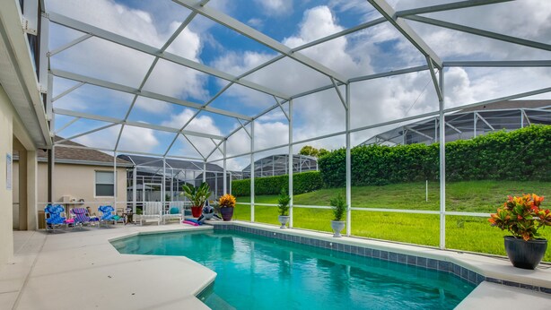 A covered swimming pool with a view of a green lawn and a house in the background. - 💥💥$40 OFF SALE TOP RATED  ALL-INCLUSIVE HOME. NEAR DISNEY PRIME LOCATION 💥💥 (Davenport)
