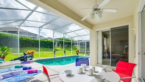 A covered outdoor patio with a pool, lounge chairs, and a dining table. - 💥💥$40 OFF SALE TOP RATED  ALL-INCLUSIVE HOME. NEAR DISNEY PRIME LOCATION 💥💥 (Davenport)