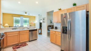 A modern kitchen with wooden cabinets, stainless steel appliances, and a view to the living area. - 💥💥$40 OFF SALE TOP RATED  ALL-INCLUSIVE HOME. NEAR DISNEY PRIME LOCATION 💥💥 (Davenport)