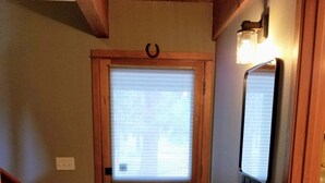 A wooden door with a window, a small staircase, and a wall-mounted light fixture.