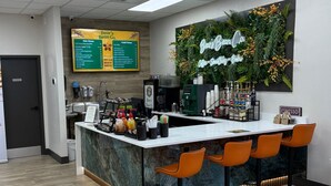 A coffee shop with a counter, bar stools, a menu board, and a wall-mounted sign. - Orlando Villa Close to Disney and Free Water Park (Kissimmee)