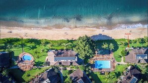 An aerial view of a beachfront property with a pool, a large building, and a designated area for a condo. - Stunning Beach Front Townhouse (Kihei)