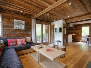 Un interior de madera con un sofá, una mesa de centro y un televisor.
