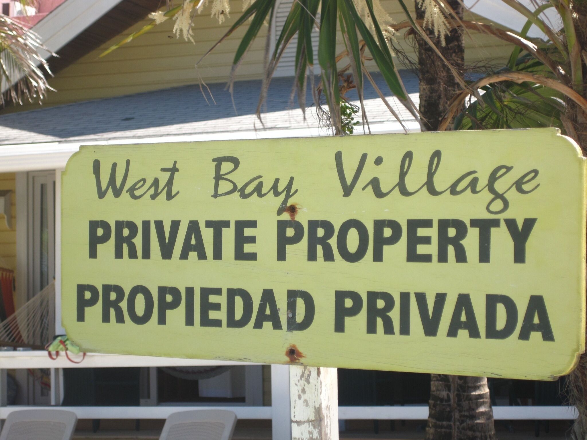 Un panneau indiquant : « West Bay Village – PROPRIÉTÉ PRIVÉE – PROPIEDAD PRIVADA ».