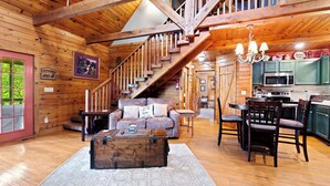 A wooden cabin interior with a staircase, living room, dining area, and kitchen. - log cabin semi -secluded ! Enjoy a nice evening by the fire-place . (Townsend)