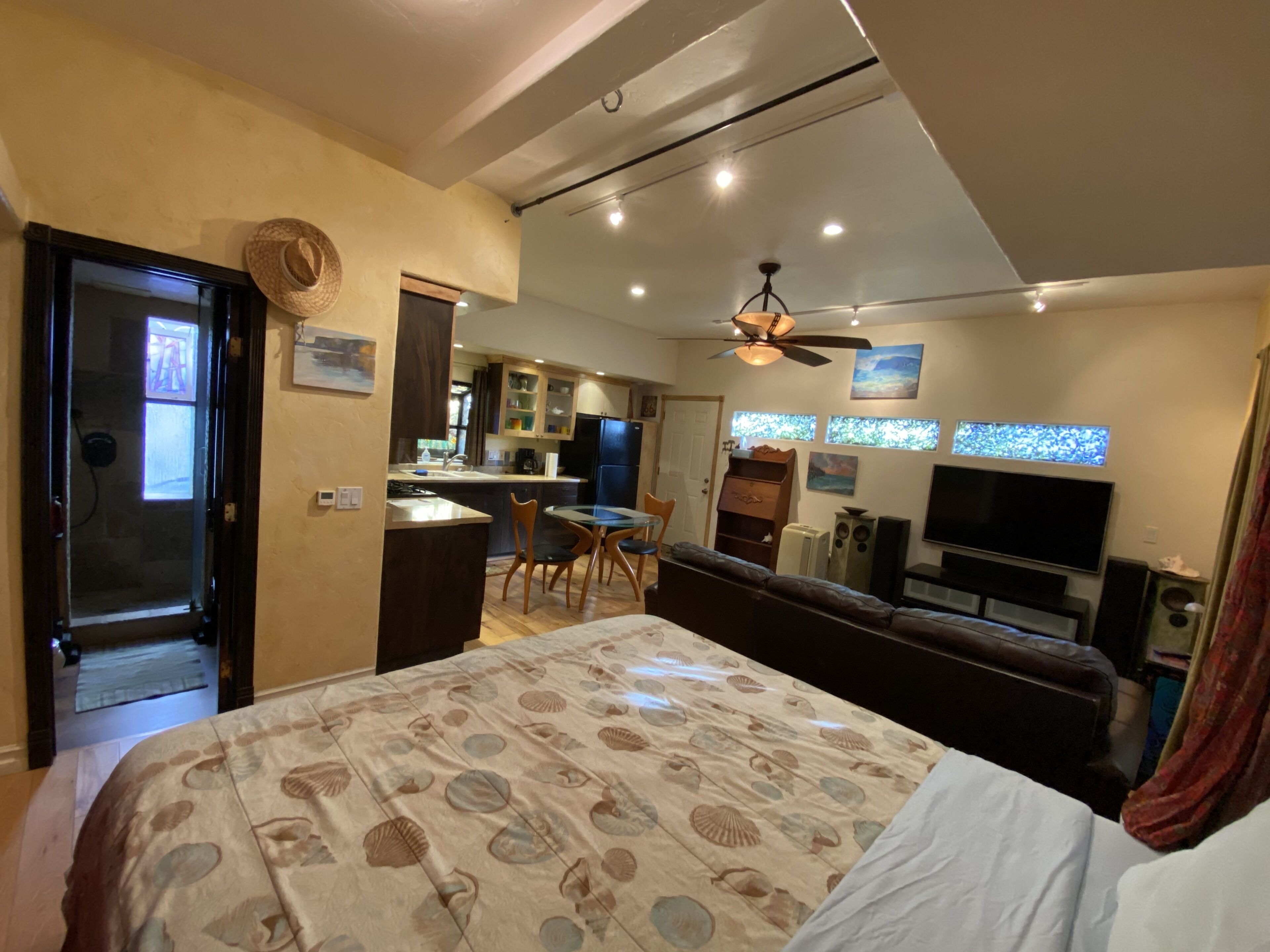 Une chambre d’hôtel moderne dotée d’un grand lit, d’un coin repas, d’une kitchenette et d’un téléviseur.