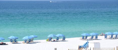Na praia, espreguiçadeiras, toalhas de praia