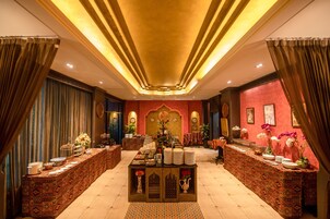 A luxurious hotel lobby with ornate decor, a central reception desk, and a warm, inviting atmosphere.