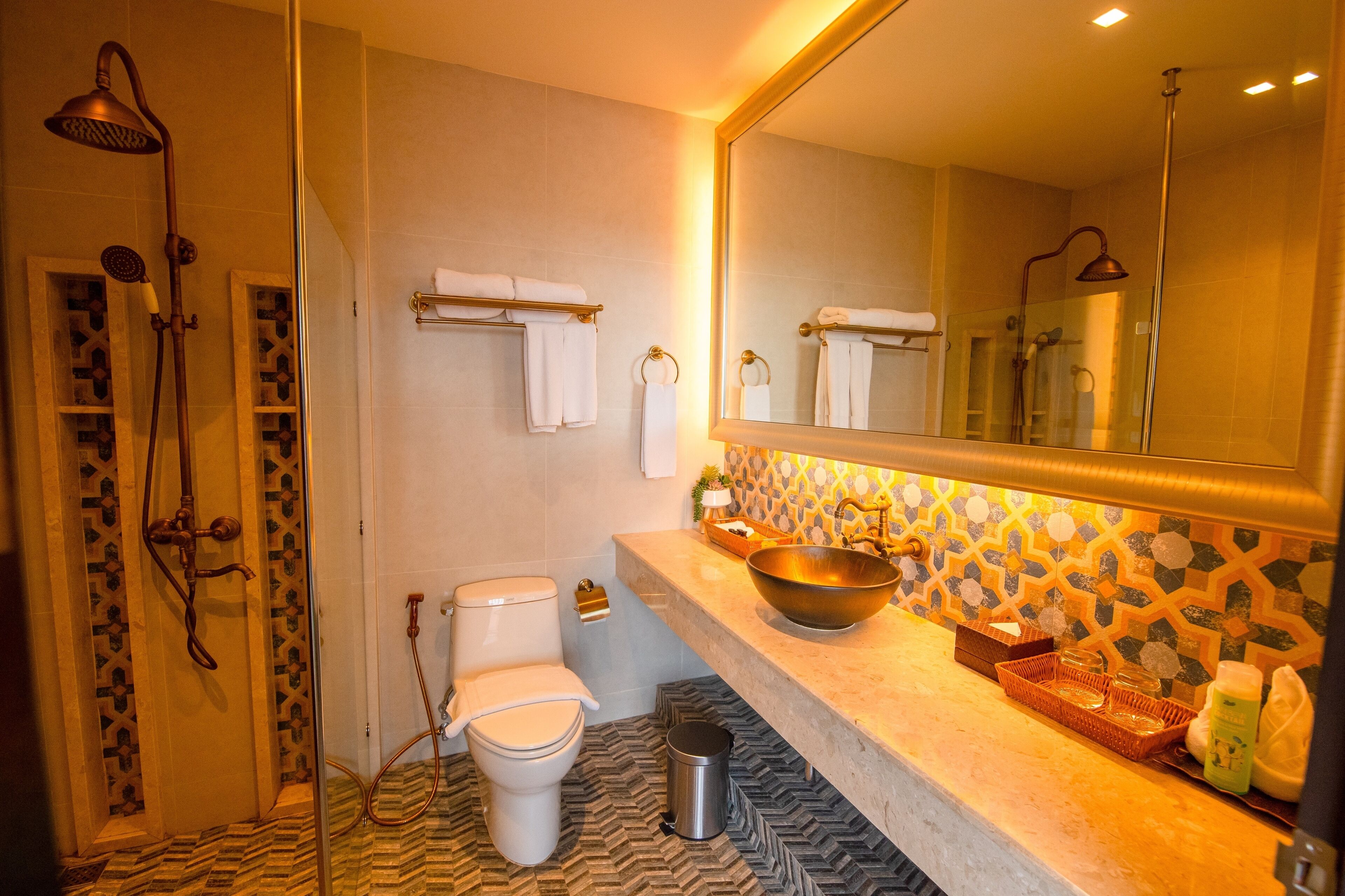Een badkamer met douche, toilet, wastafel en een grote spiegel.