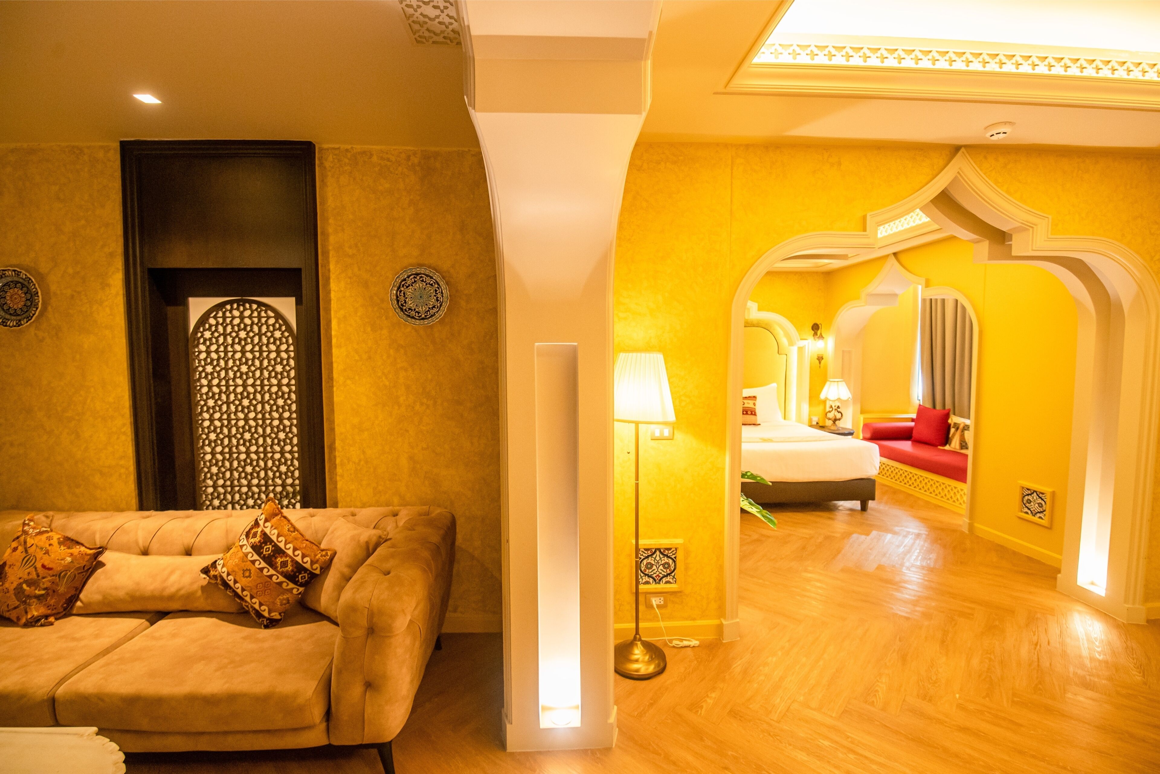 Una habitación de hotel con sofá, lámpara y cama.