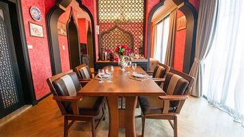 A dining area with a wooden table, six chairs, and a decorative wall with a patterned screen.
