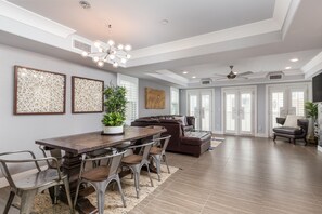 Relax in this stylish living area with a dining table, comfortable sofa, and dark leather chair.