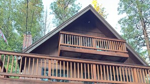 A two-story cabin with a balcony, a garage, and a chimney. - Perfect Sierra Cabin Retreat - Near Rivers, Lakes, and Mountains (Twin Bridges)