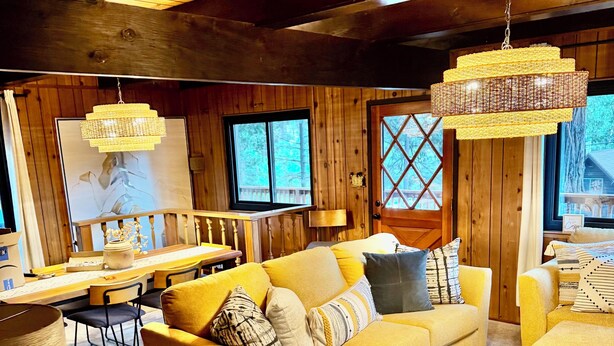 A cozy living room with a yellow sofa set, a coffee table, and a chandelier. - Perfect Sierra Cabin Retreat - Near Rivers, Lakes, and Mountains (Twin Bridges)