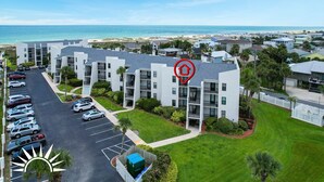 A multi-story residential building with a parking lot, surrounded by greenery and a beach view. - Island South 27- Updated, Spacious 2 bedroom condo with ocean view, pool and (St. Augustine)