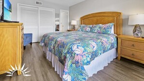 A bedroom with a bed, wooden nightstands, a ceiling fan, and a wardrobe. - Island South 27- Updated, Spacious 2 bedroom condo with ocean view, pool and (St. Augustine)