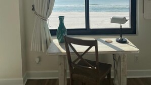 A room with a view of the ocean, a wooden chair, a desk, a lamp, and a vase. - Upgrades Galore! STUNNING Views, Steps to the Sand & Short Walk to FLORA-BAMA!! (Orange Beach)