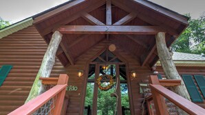 A wooden cabin with a porch, a wreath on the door, and a sign that reads "Rio".