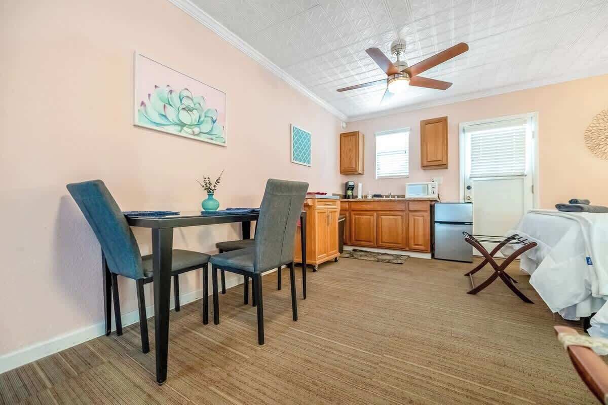 A compact living space with a dining area, kitchen, and a ceiling fan.