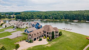 Une grande maison à plusieurs étages, dotée d’une allée spacieuse et d’une pelouse bien entretenue.