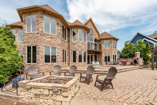 Una casa de piedra con varias ventanas y un patio con mobiliario de exterior.