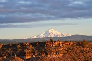 Une montagne dont le sommet est enneigé, avec des falaises rocheuses et une végétation clairsemée.