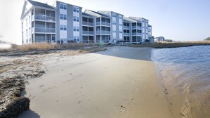 A beachfront hotel with multiple balconies, a sandy beach, and a calm sea. - 2 story condo w/ Stunning Views and Many Amenities (Ocean View)