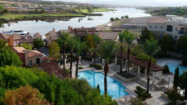 A resort with a swimming pool, palm trees, and a view of a lake. - TRANQUIL SETTING IN 6TH FLOOR, 1 BEDROOM 1 BATH CONDO WITH BREATHTAKING VIEW  (Henderson)